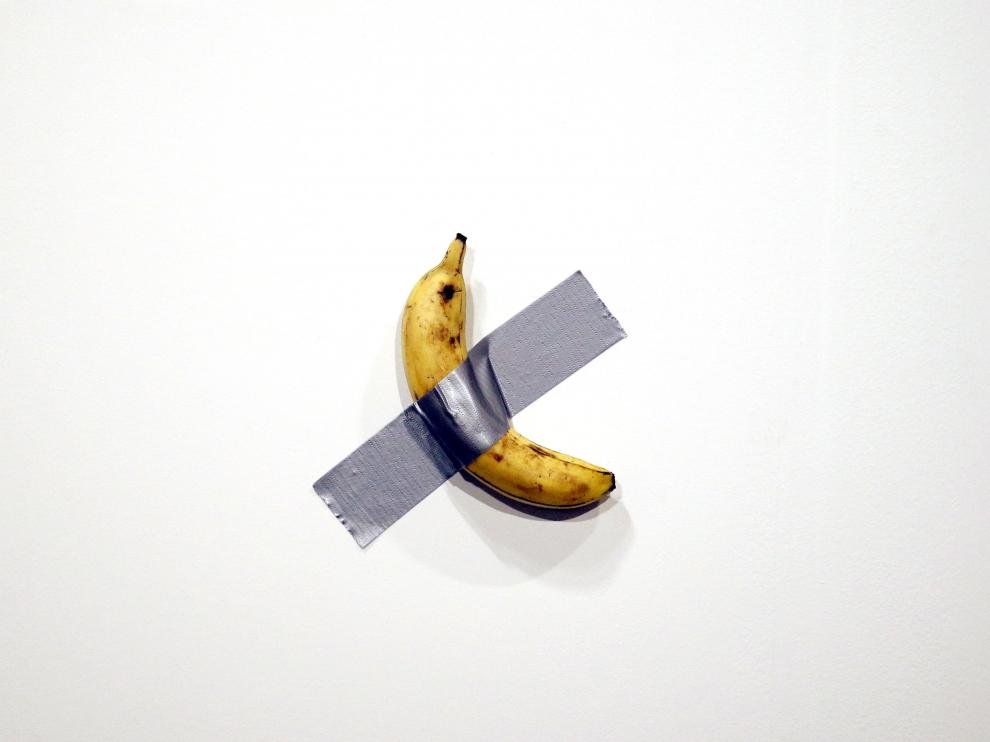 un artista se come la obra platano de cattelan en el art basel miami